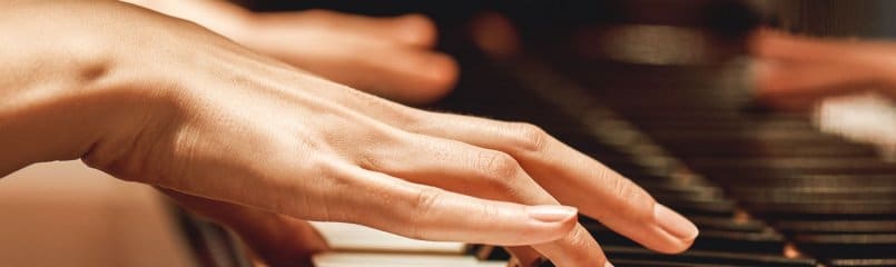 close-up of woman's hands playing the piano