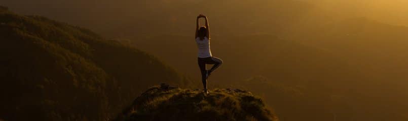 woman doing yoga pose on a mountain