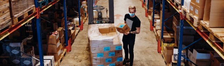 man in a warehouse holding a box
