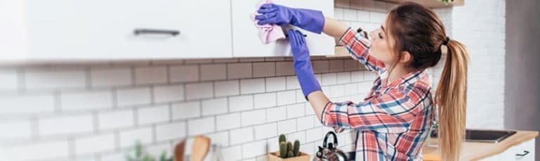 woman cleaning kitchen cabinets