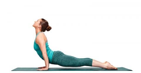 A girl stretches on a yoga mat.