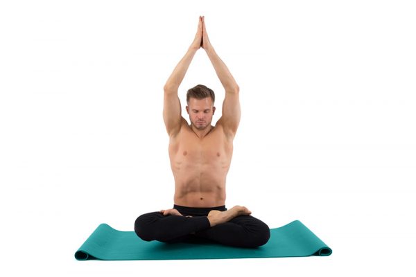 A yoga teacher meditates in a pose.