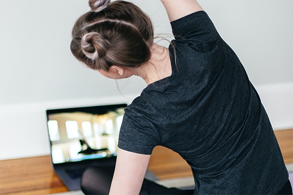 A student practices yoga from an online instructor