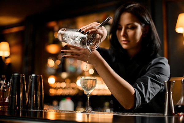 A bartender pours a drink.
