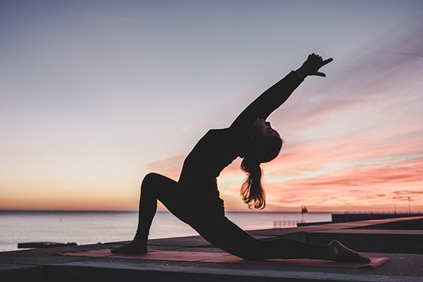 A yogi practices yoga at sunset.