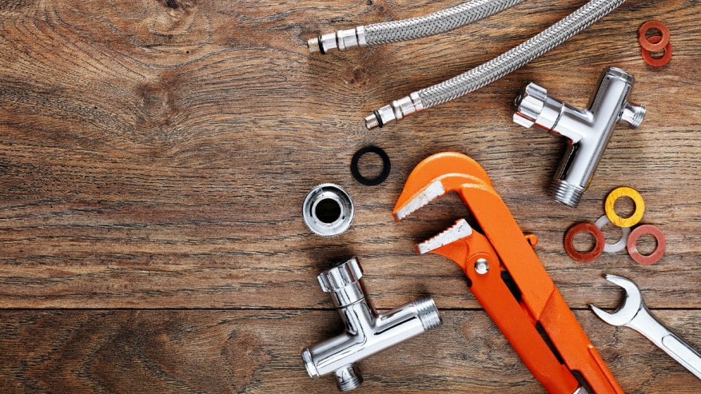 Plumbers tools on a wood background