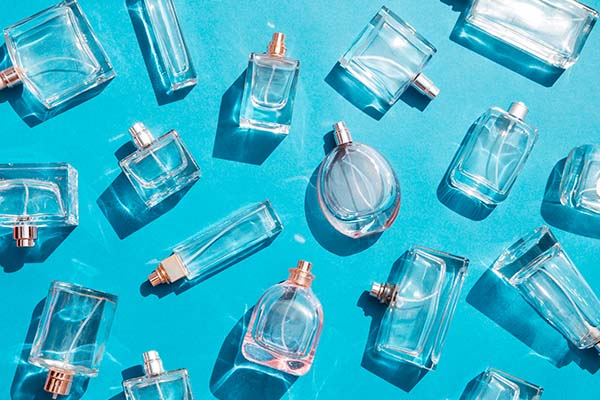 Empty cologne and perfume bottles on a blue background.