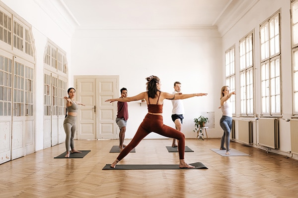 A yoga instructor uses her yoga insurance to lead her class in a pose.